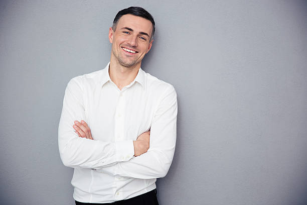 istock Smiling businessman standing with arms folded 473749898