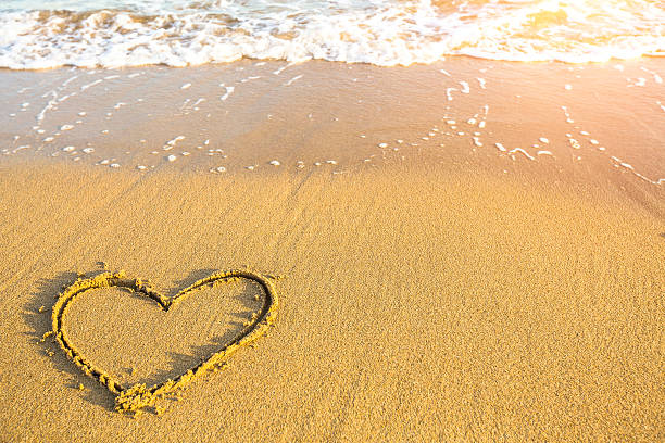 istock Heart drawn on the sand of ocean beach. 473768348