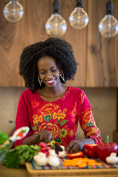 istock Black woman cutting mushrooms 473778474