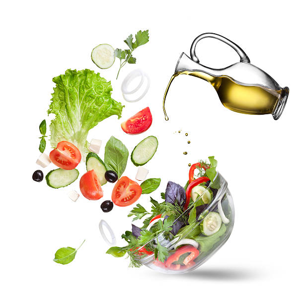 caída de verduras aislados y aceite de ensalada - salad ingredient fotografías e imágenes de stock