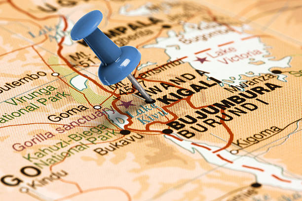 Series: Travel the world and visit major cities. Blue thumbtack (push pin) that is stuck in a map, which marks the city of Kigali, Rwanda. The map is toned in pastel colors. Concept: Planning travel destinations or journey planning. Close-up view. Studio shot. Landscape orientation.