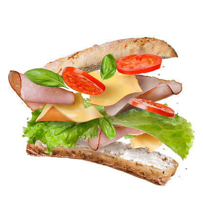 Sandwich with falling ingredients in the air isolated on white - slices of fresh tomatoes, ham, cheese and lettuce