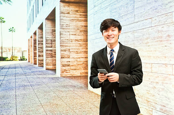istock Smiling businessman using mobile outdoors 473782198