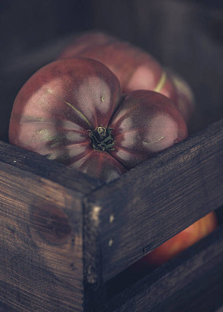 bio frais de l'intérieur les tomates d'héritage dans caiss'en bois.   alimentation saine. - heirloom tomato food tomato crate photos et images de collection