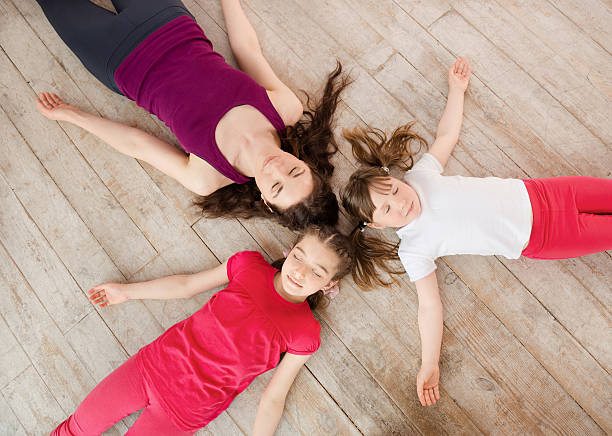Young mother and daughter lying on the floor stock photo