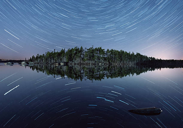 star trails reflejado en el lago - star trail clear sky tranquil scene circle fotografías e imágenes de stock