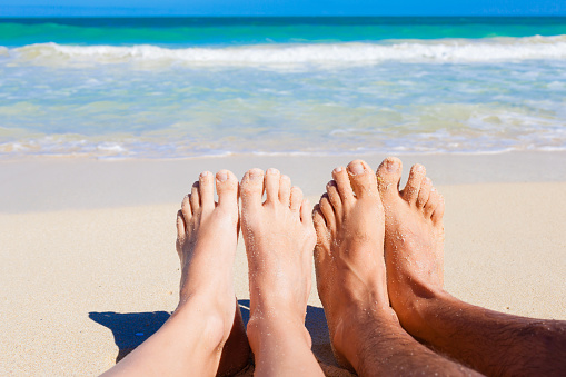 Leisure summer vacation - young gorgeous woman with hidden identity lays at the beach and at sea with turquoise color