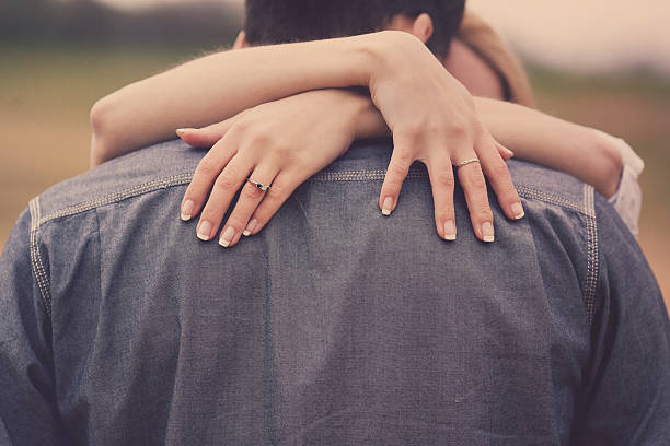 istock Couple Hugging Hands Over Shoulders with Ring 473791868