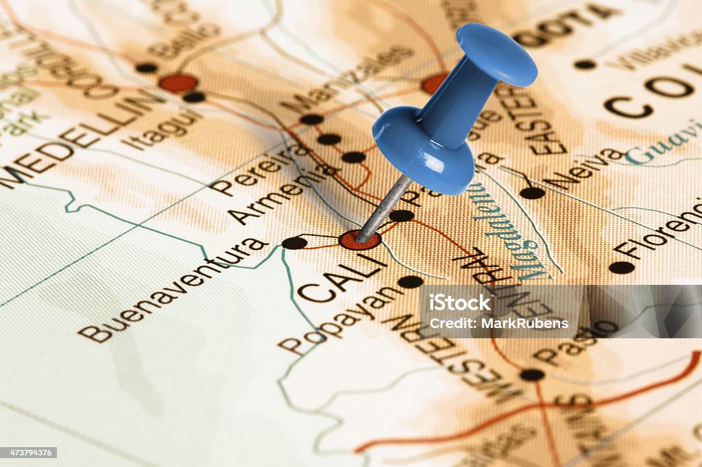 Location Cali. Blue pin on the map. Series: Travel the world and visit major cities. Blue thumbtack (push pin) that is stuck in a map, which marks the city of Cali, Colombia. The map is toned in pastel colors. Concept: Planning travel destinations or journey planning. Close-up view. Studio shot. Landscape orientation. Cali - Colombia Stock Photo