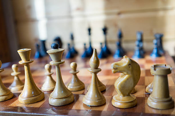 istock Line of white pawn chess pieces against black 473795918