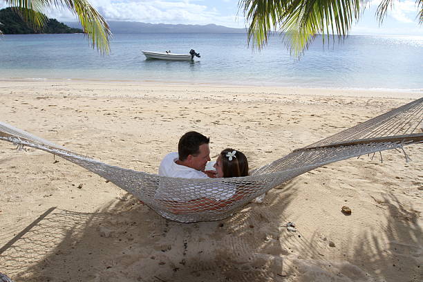 Newly-Weds Gazing into Each Other's Eyes in Hammock, Fiji stock photo