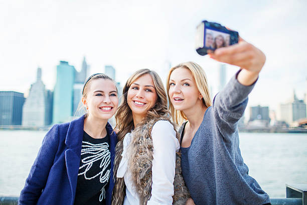 istock Three girlfriends taking selfie outdoors 473821944