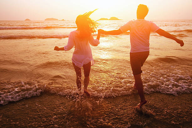 coppia felice sulla spiaggia - couple romance running freedom foto e immagini stock