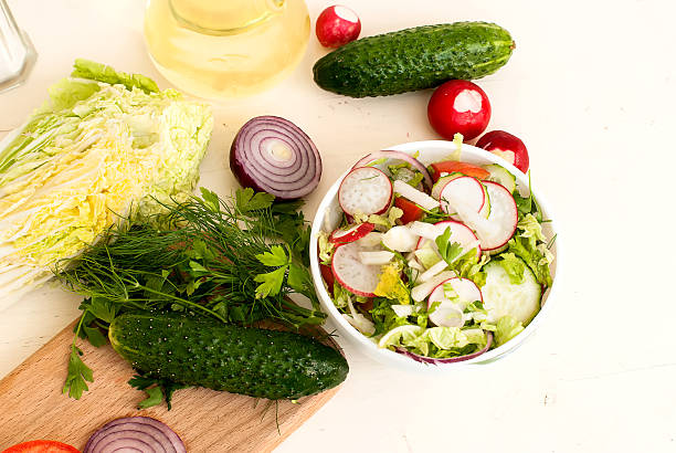 istock Spring salad with radishes, cucumber, cabbage and onion close-up 473822912