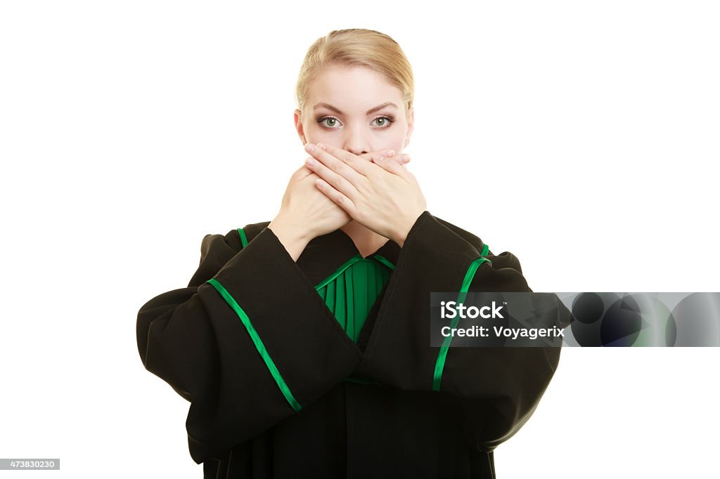 Woman lawyer barrister covering mouth with hands. Confidential information. Law court or justice concept. Woman lawyer barrister wearing classic polish black green gown covering mouth with hands. 2015 Stock Photo