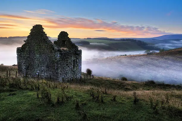 The remains of the 16th Century Mervinslaw Tower, near Jedburgh in the Scottish Borders. Image taken on an early autumn morning at sunrise, looking towards the English border.