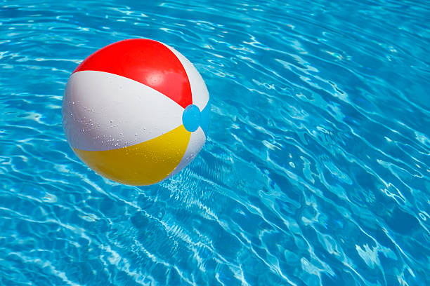 istock Beach ball party in a blue water swimming pool 473834622