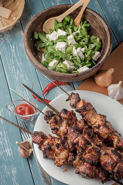 istock Shashlik with salad on the wooden table. 473834704