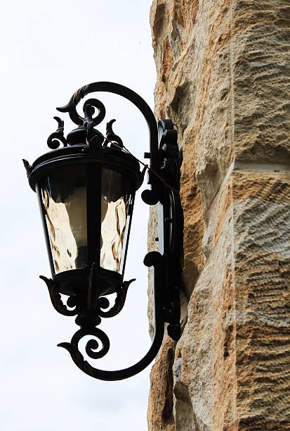 istock Black metal outdoor light on sandstone brick wall 473835132