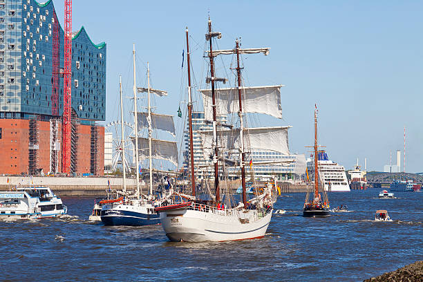 Hollern-Twielenfleth, Germany - September 7, 2020: Historic barque PEKING  on Elbe river being towed to German Port Museum at Hamburg, accompanied by spectators on modern and historic boats