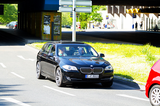 Essen, Germany - May 15, 2015: Capture of a BMW Touring car standing at traffic light in Essen. Inside are two muslim women. Driving women is wearing a headscarf. Scene is close to Porschekantel and jewish synagogue.