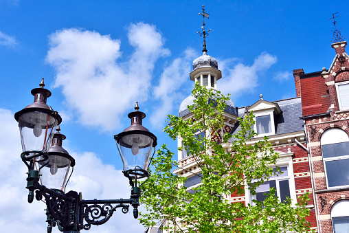 Old town houses in a historic city of the Netherlands. View to an old, decorative lantern and beautiful historic house facades of the turn of the century.