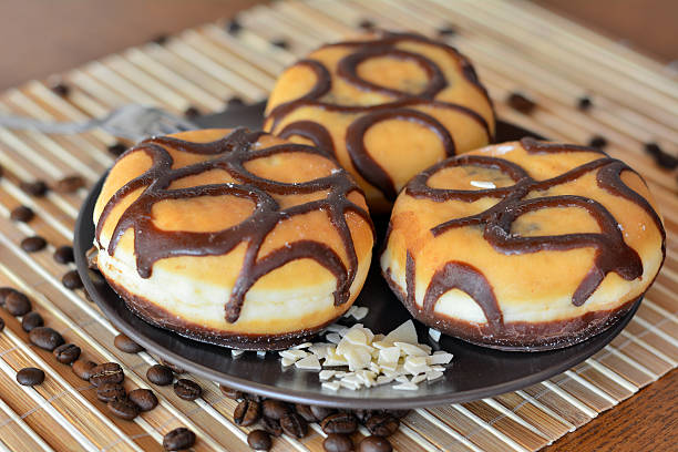 istock Three traditional donuts with chocolate on the brown plate 473851124