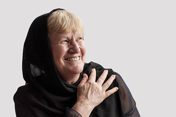 ederly mujer agarrando su jefe cubierta - headscarf islam senior adult east fotografías e imágenes de stock