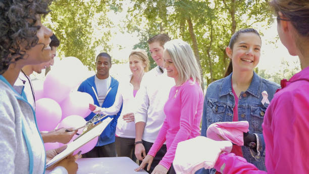 istock Diverse runners registering for breast cancer awareness race 473863208