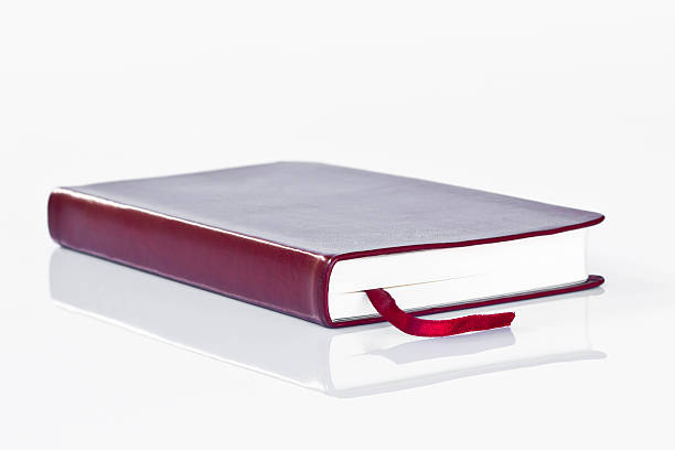 istock Little red leather covered book, closed, isolated on white. 473863348