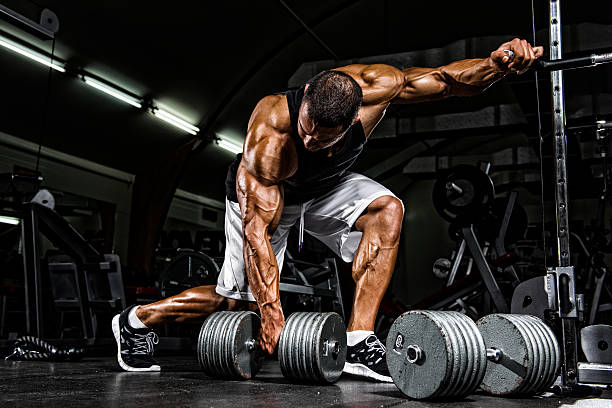 Hardcore Workout Body Builder preparing to lift heavy dumbbell. Copy Space body building stock pictures, royalty-free photos & images