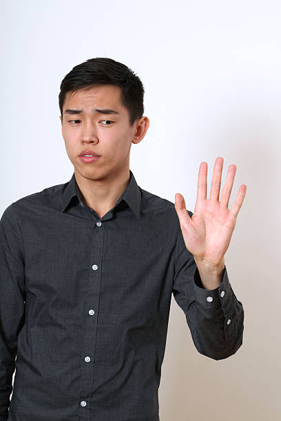 istock Strict young Asian man giving the stop sign 473880898
