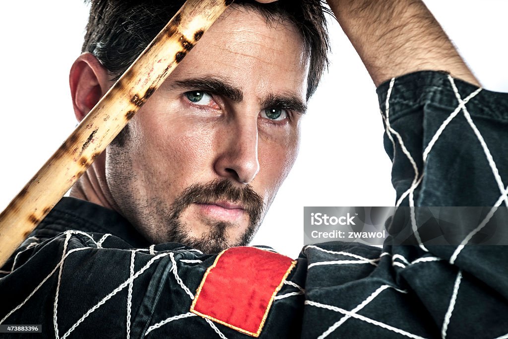 Martial arts master with bamboo sticks Martial arts master with black combat dress and two short bamboo sticks, isolated on white background 2015 Stock Photo