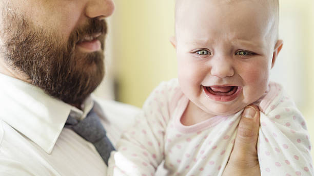 istock Man with beard holding up a baby girl 473894380