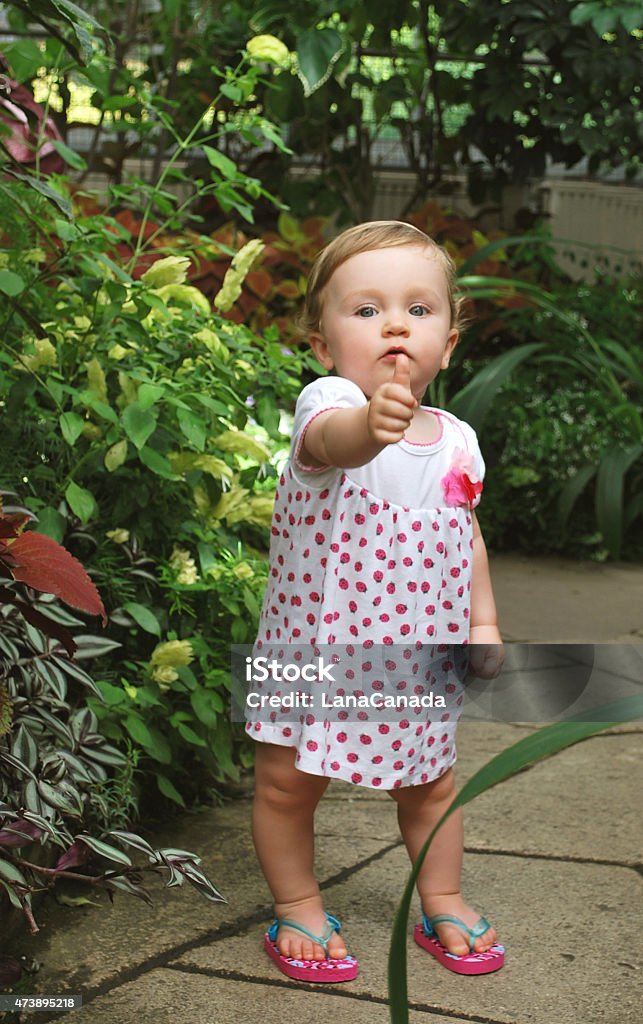 Little Caucasian girl in a garden 12-17 Months Stock Photo