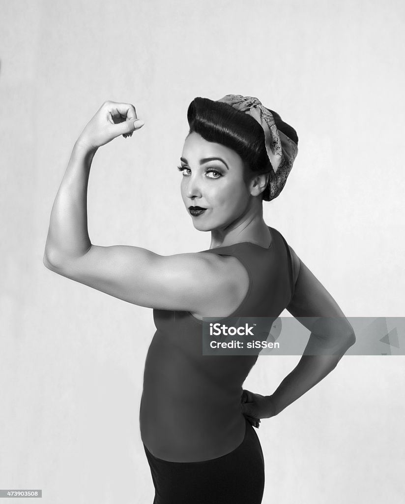 woman biceps show-off woman brunette in a blue shirt with a scarf on her head and hair in a retro style biceps show-off Women Stock Photo
