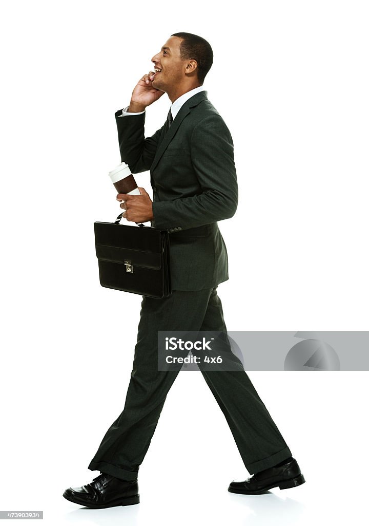 Smiling business on mobile and walking Smiling business on mobile and walkinghttp://www.twodozendesign.info/i/1.png Businessman Stock Photo