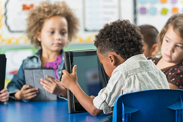 istock Multiracial children in kindergarten with digital tablet 473906128