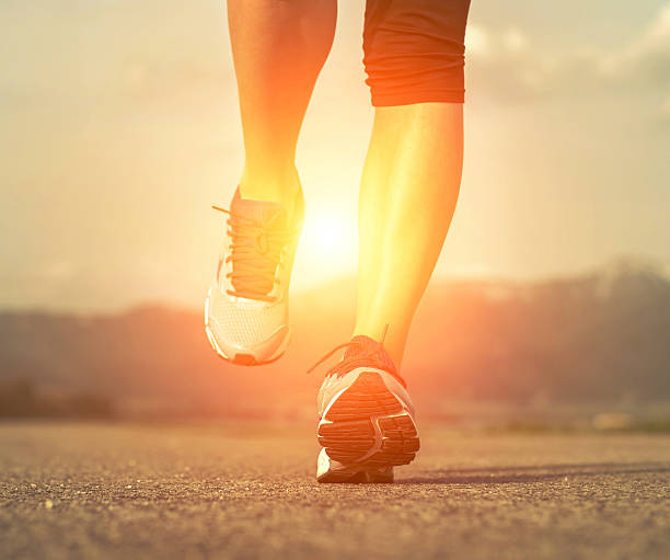 istock Runner athlete feet running on road under sunlight. 473906560