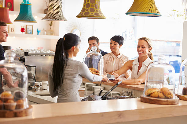 istock Woman paying for her order in a cafe 473909144