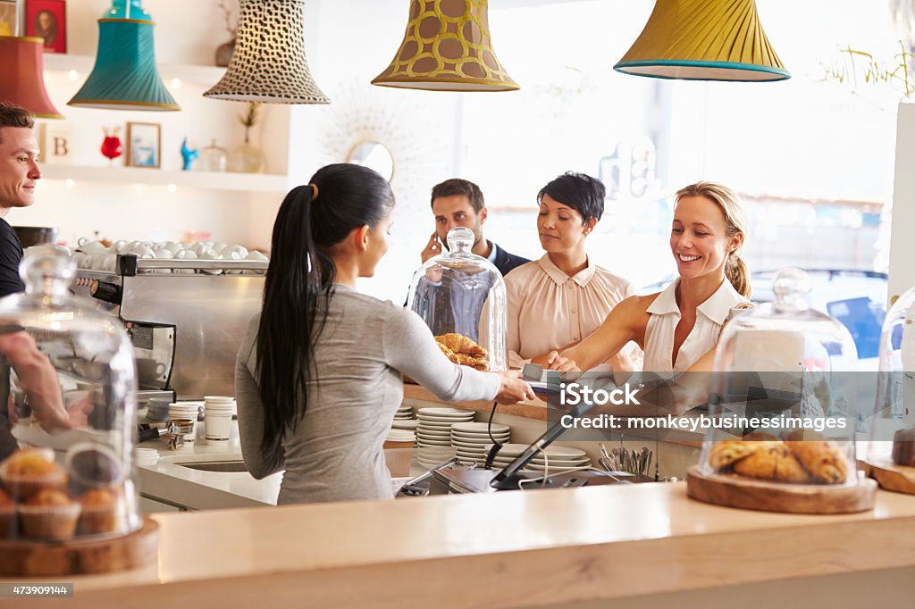 Woman paying for her order in a cafe Cafe Stock Photo