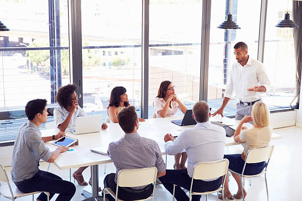 empresario la presentación a sus colegas en una reunión - fines del período moderno fotografías e imágenes de stock