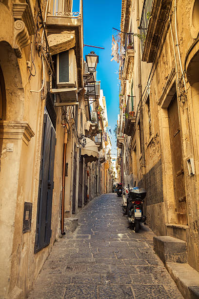 istock narrow street with parked motorcycles 473915910