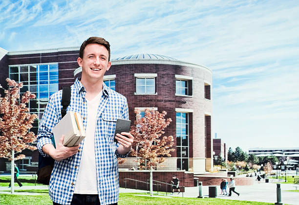Smiling student in campus and holding books
