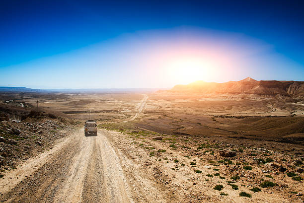 istock Jeep in a desert road 473916416