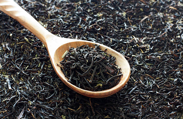 istock Spoon of  dried black tea leaves 473920612
