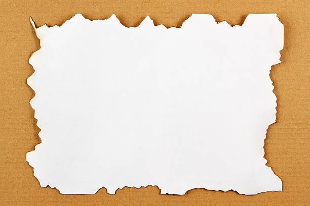 istock White Paper with Burnt Edges on Brown Cardboard Background 473935546