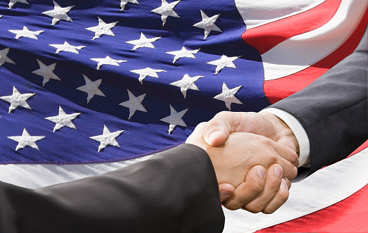 Handshake over american national flag background. Partnership and  politics concept