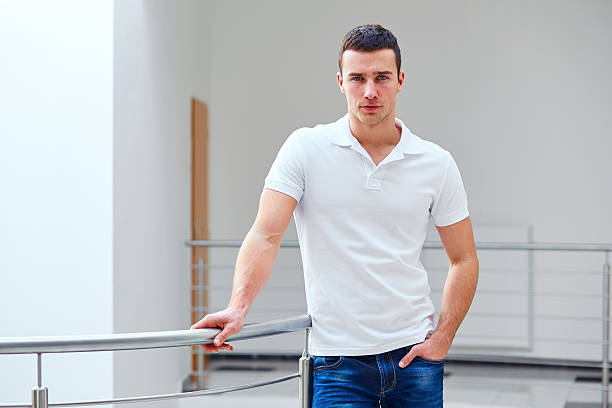 istock Man in a polo shirt stands leaning on railing 473937426