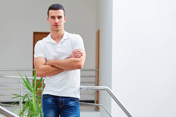 istock Man in a polo shirt stands leaning on railing 473939828